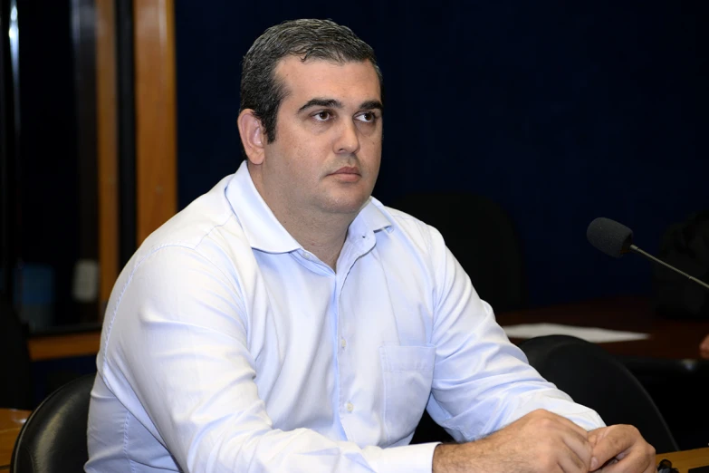 a man sitting down at a table with microphone