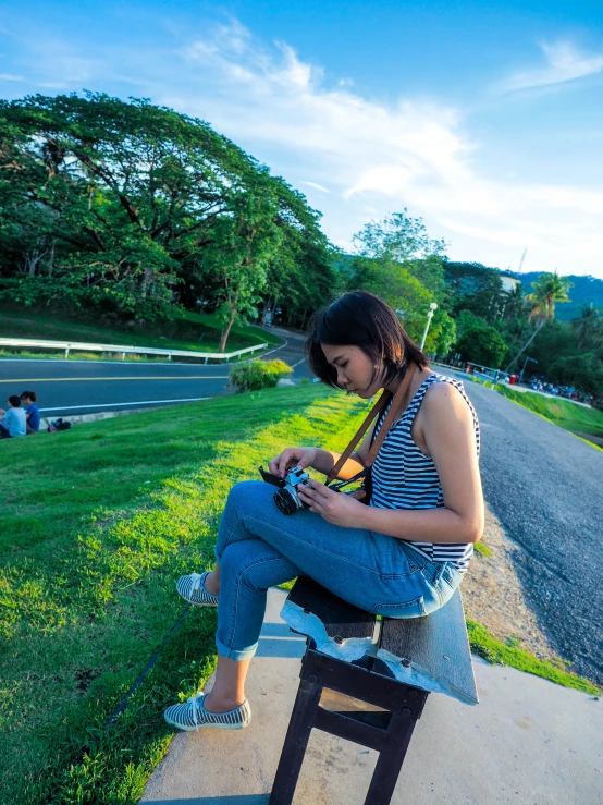 a woman in striped shirt sitting on a bench