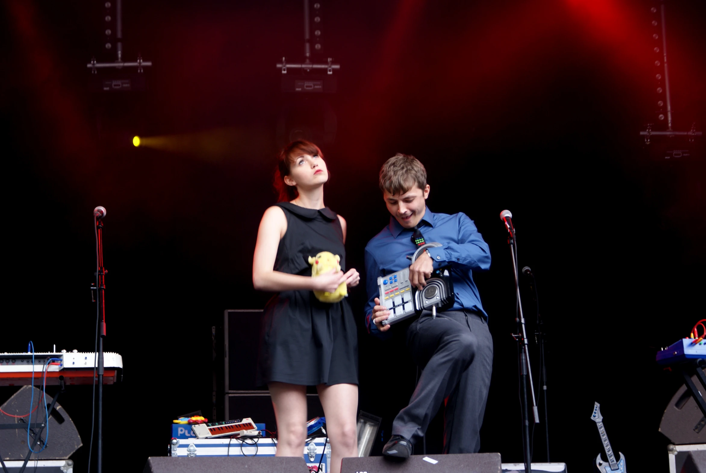 a young man and woman singing on stage with microphones