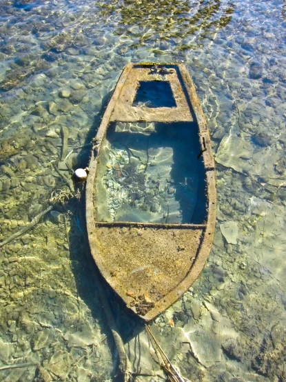 an old boat is sitting in shallow water
