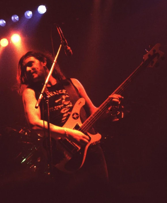 a man with long hair, a beard and playing the guitar on stage