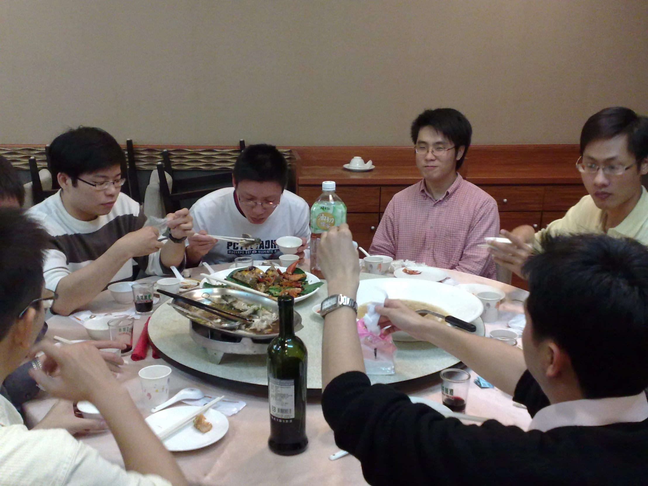 five asian people at the table enjoying meal together