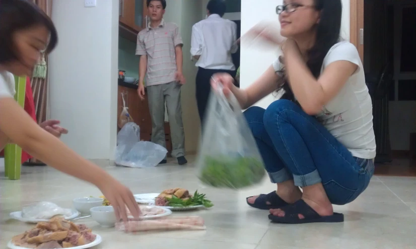 woman with plastic bag on floor preparing food for her friends