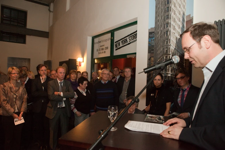 a man standing in front of a microphone talking into a microphone