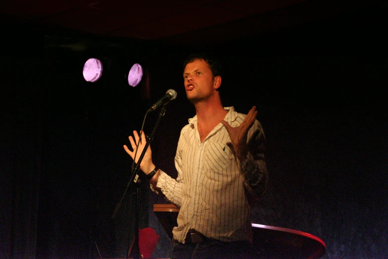 a man speaking into microphone at an event