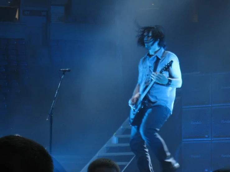 a guy playing guitar on stage with another man