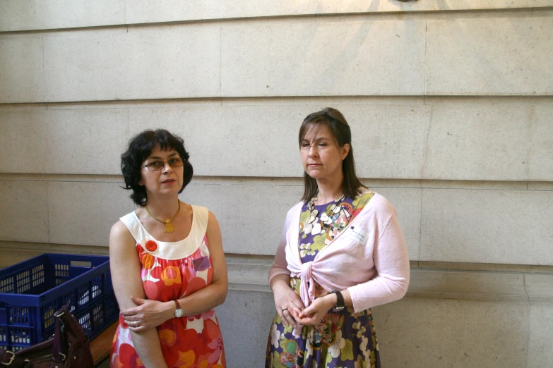 two women posing for a picture in front of a building