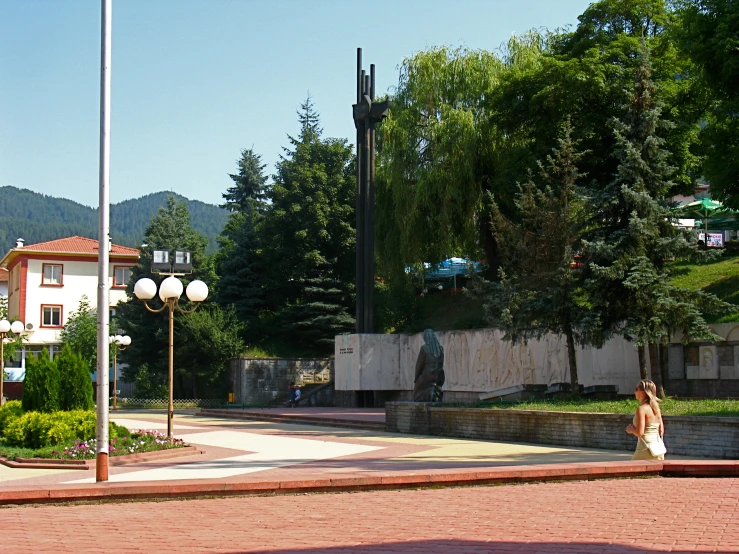 a woman is walking past an outdoor sculpture