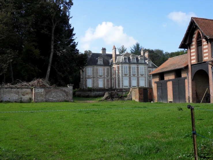 an old house sitting on top of a lush green field