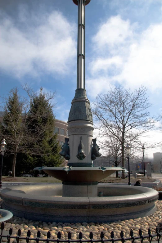 the statue is on top of a circular pole