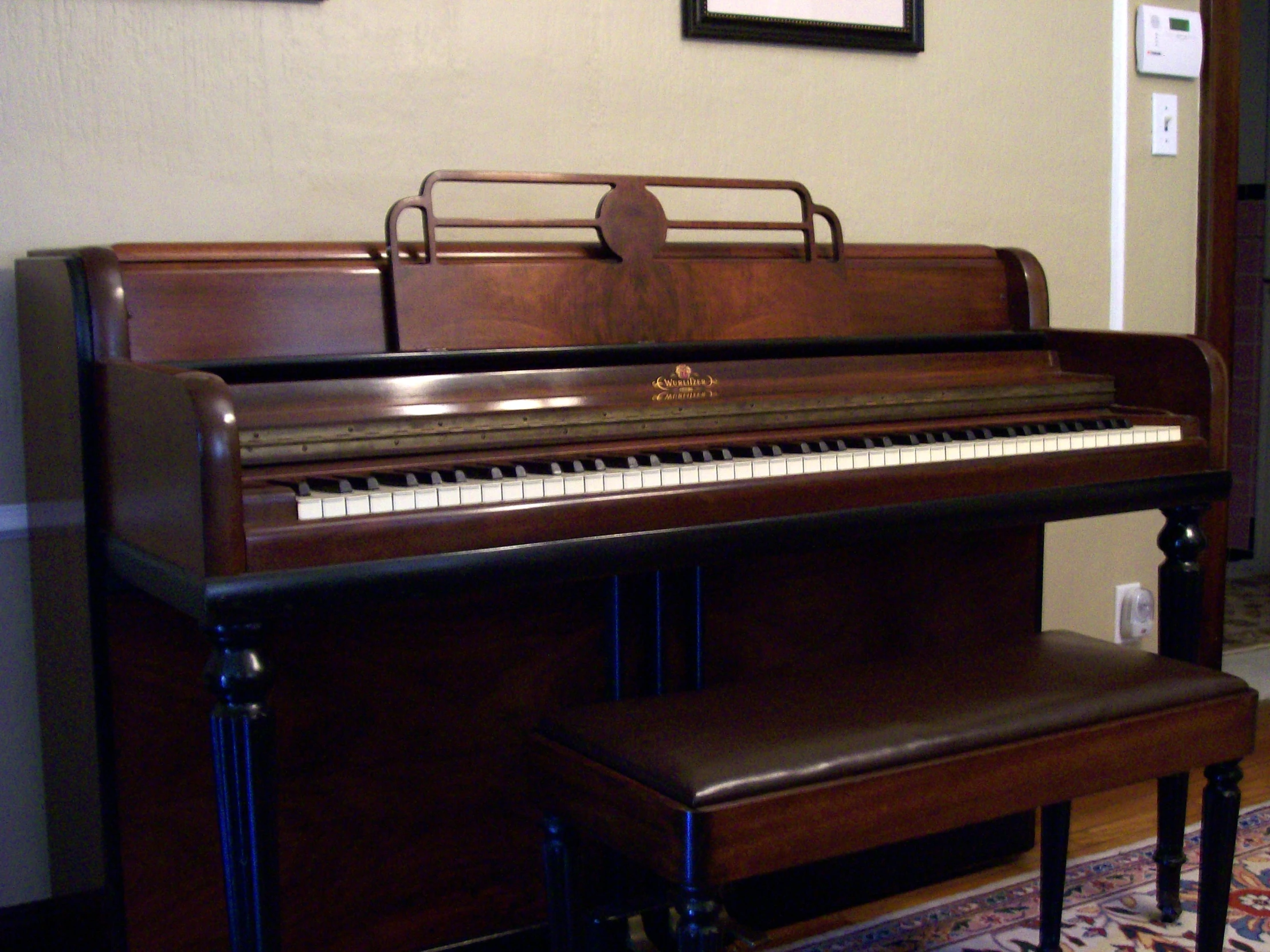 a piano sitting next to a framed picture