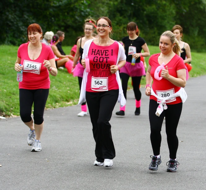 two females are jogging with runners in the background