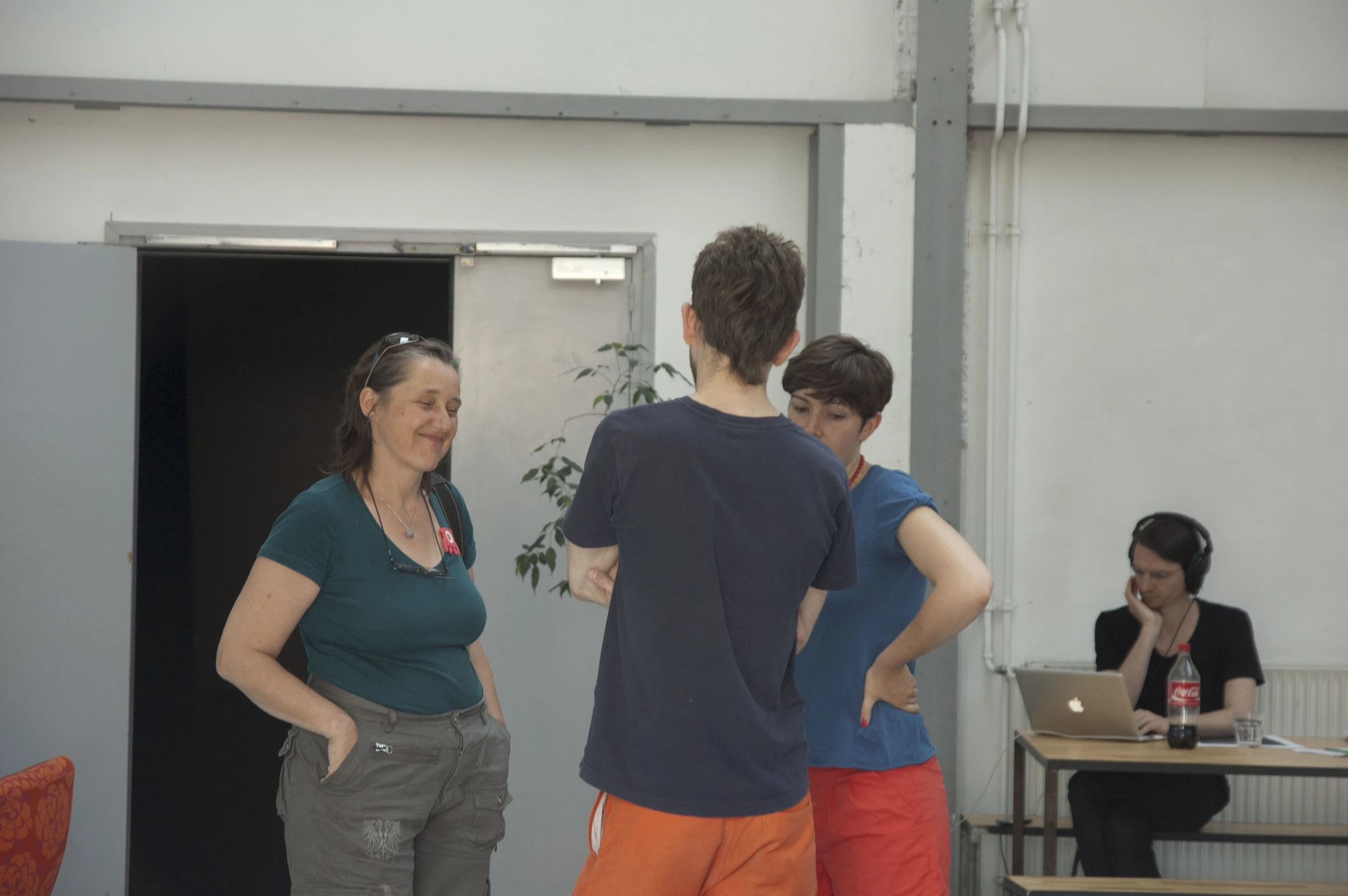 three people that are standing in front of some laptops