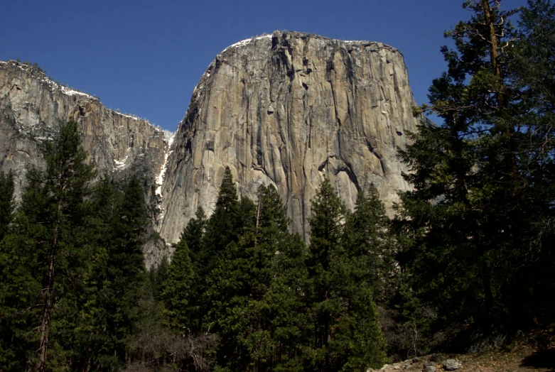 a view of mountains, trees, and clear sky