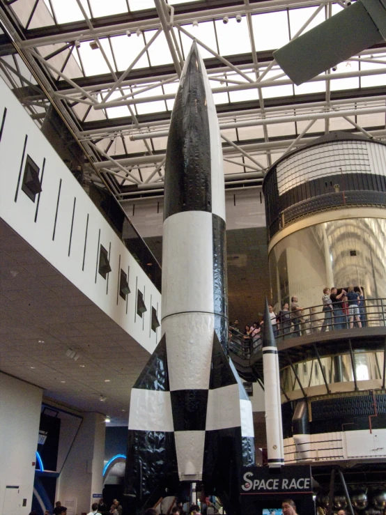 a black and white rocket with some people around it