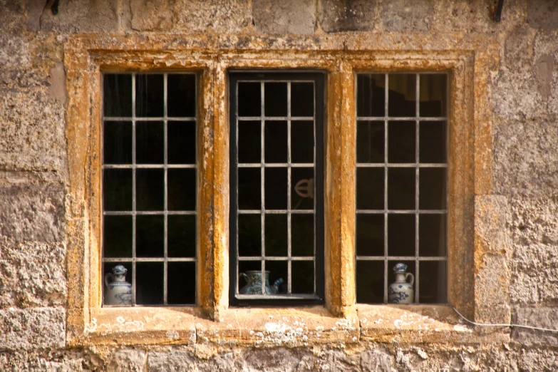 two cats are looking out the windows of an old building