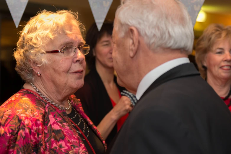 an older man and woman in formal wear at an event