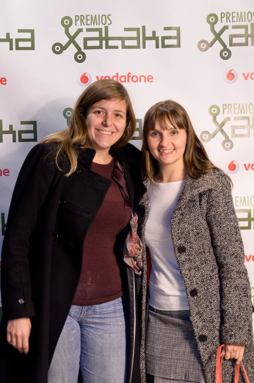 two women standing next to each other on a red carpet