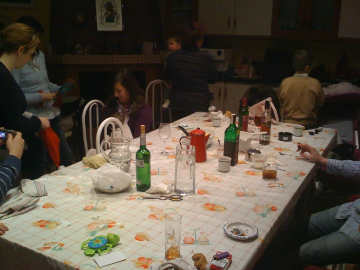 people sitting around a dinner table with a lot of empty glasses