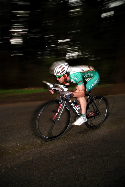 cyclist in bib riding fast on a country road