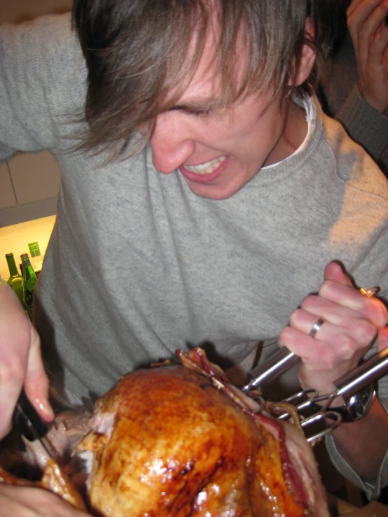 a young man is grabbing the lid off a turkey