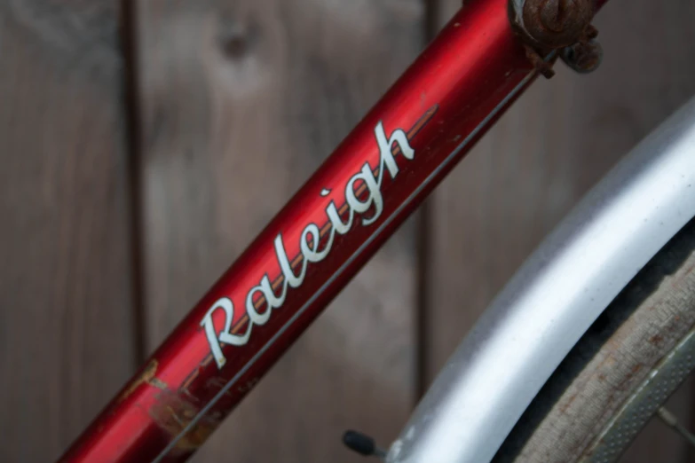 close up of red bike on wooden background