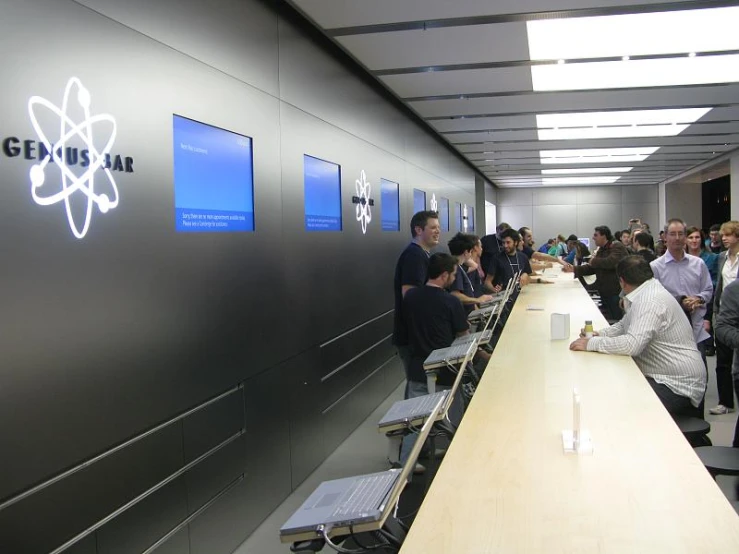 many people are at the long table with computers