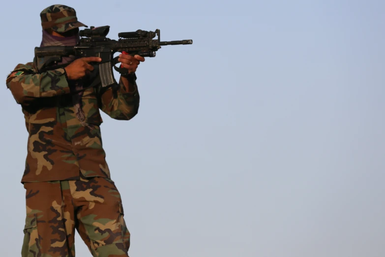 a soldier with a weapon stands with his rifle