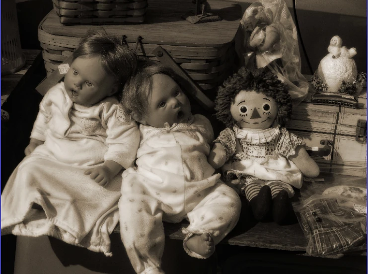 three baby dolls are lying on top of a bench
