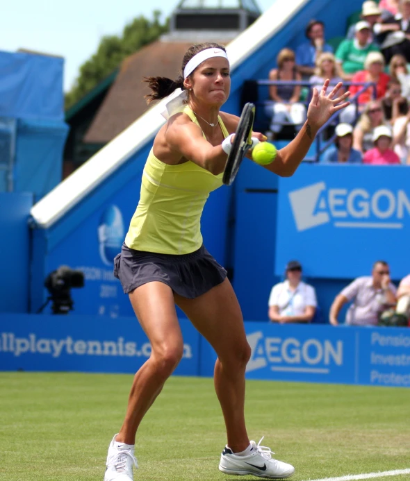 a woman tennis player returning a ball with her racket