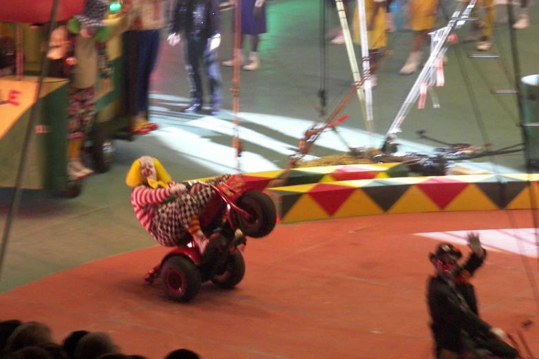 a circus performer on a four wheeled toy horse