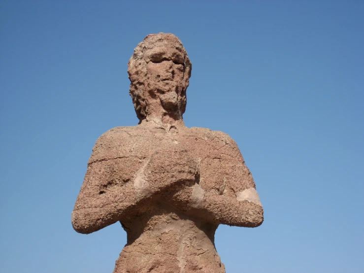 a sand statue in front of blue sky