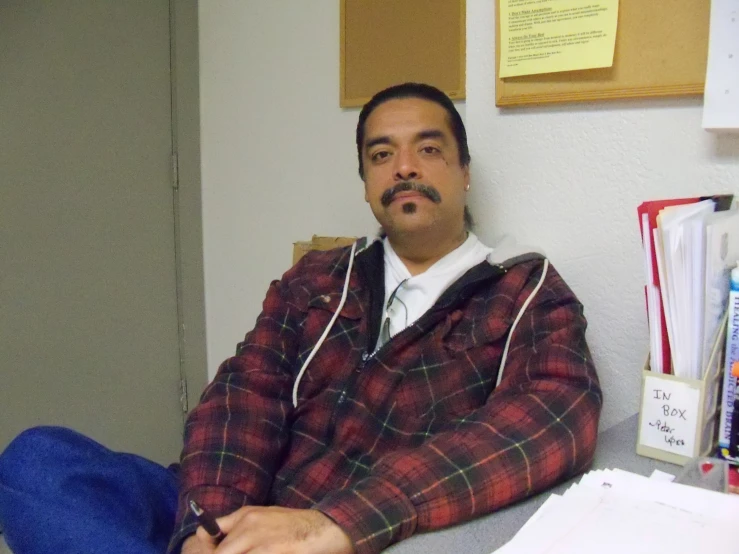 a man in plaid shirt sitting on couch