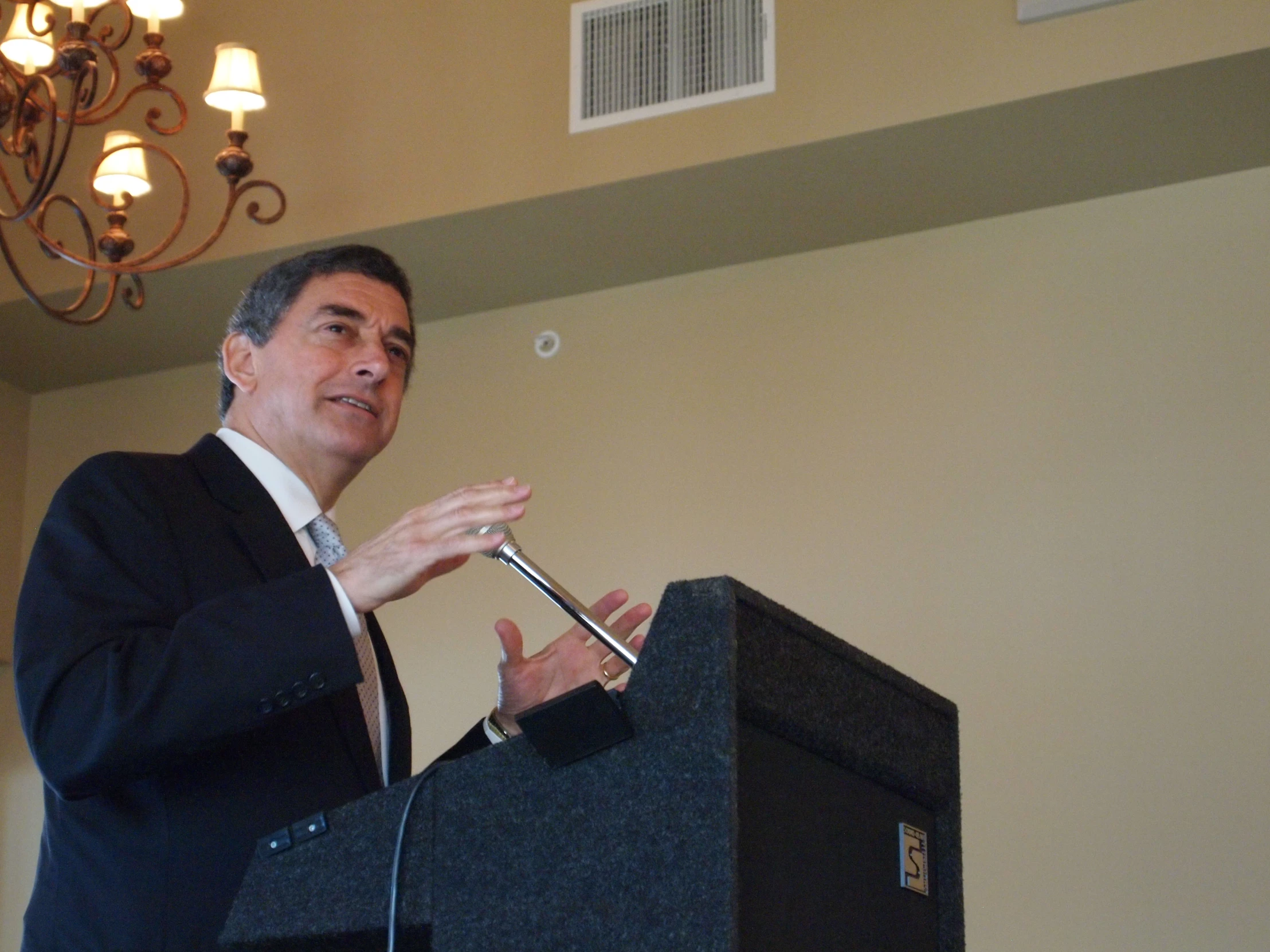 a man with a black jacket is giving a speech