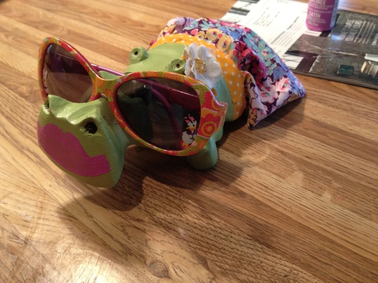 a pair of sunglasses laying on top of a wooden table