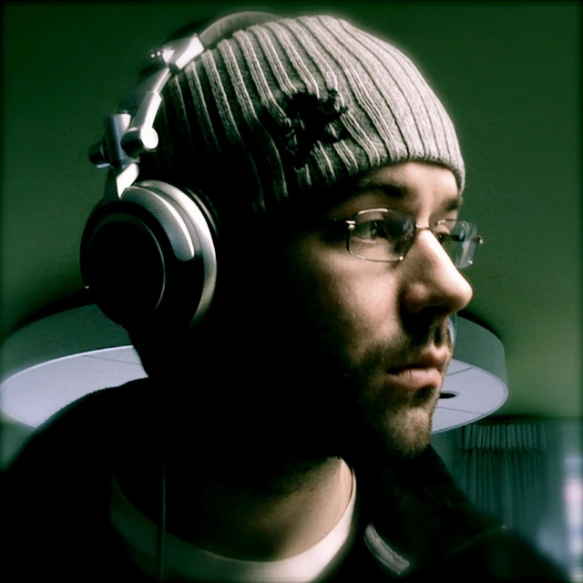 a man with headphones on staring off into the distance