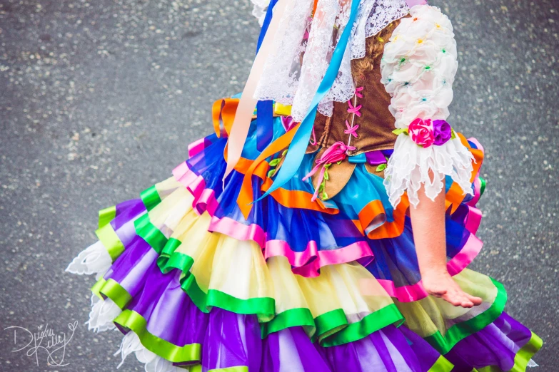 a woman in colorful clothing standing in the street