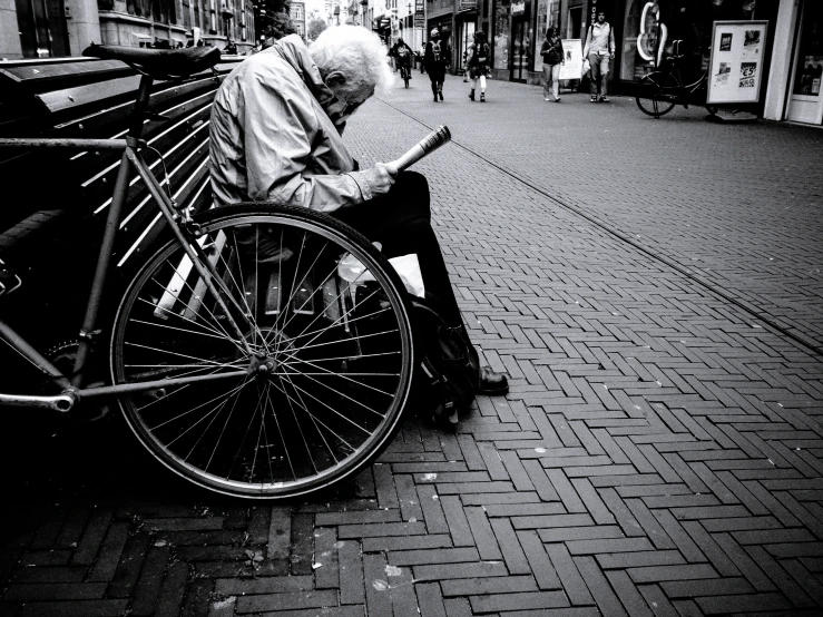 an old man on a bench in the middle of a town