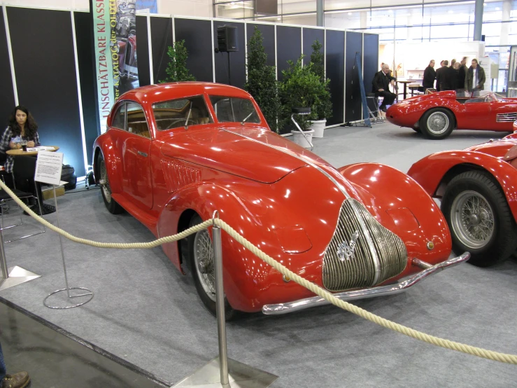a red car is on display in a museum