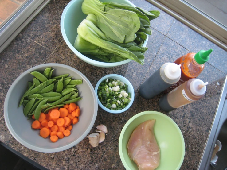 a table topped with bowls of vegetables and sauces