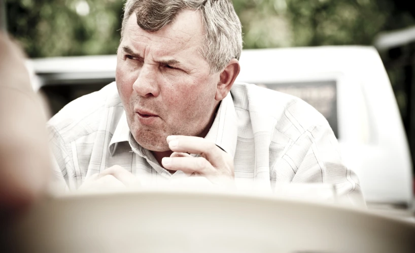 a man in a tie and shirt staring out a window