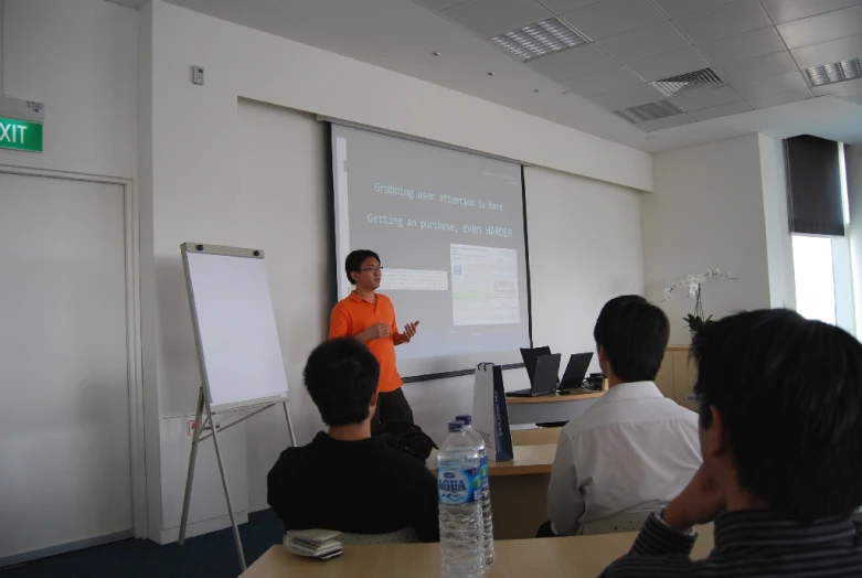 two people standing near a large screen presenting a project