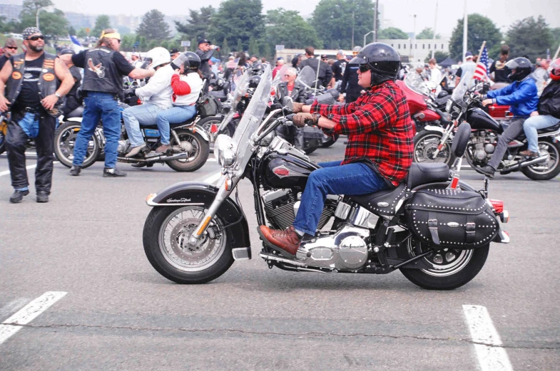 a guy riding a motorcycle with many other people in the background