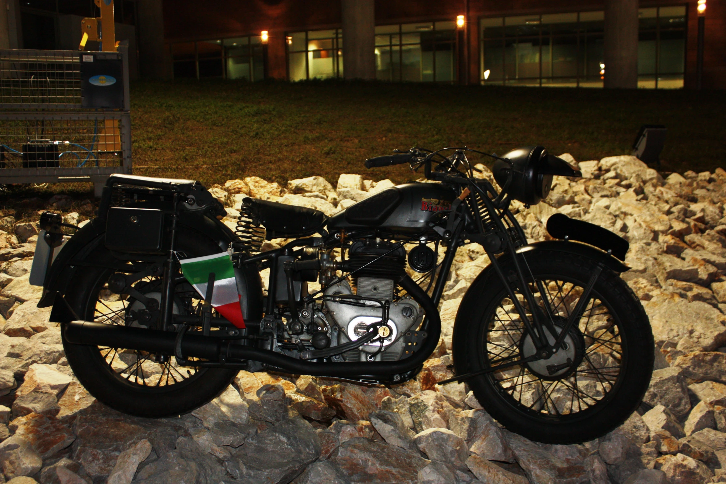 a motorcycle with italian flag paint sitting on a pile of rocks