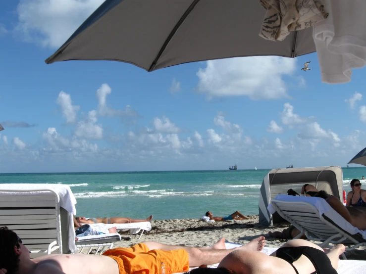 a number of people relaxing on beach chairs near the water