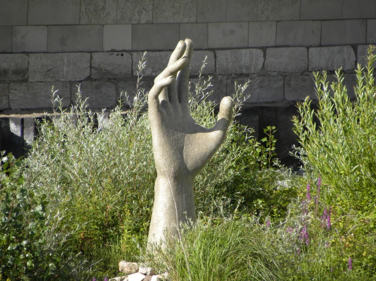 there is a statue of two hands reaching up