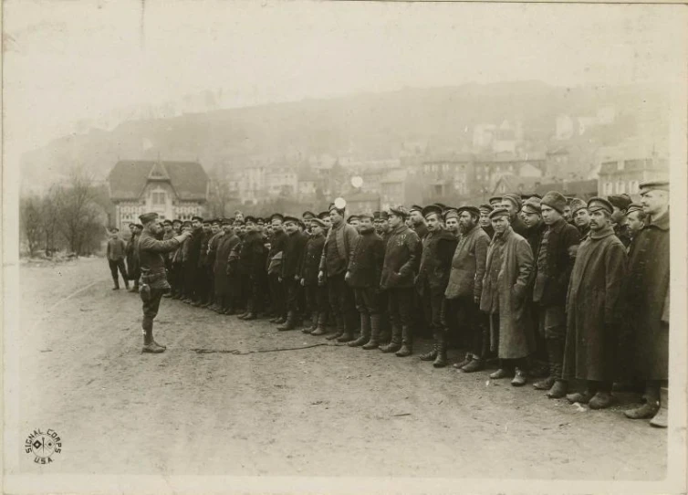 men in uniforms are standing on the side walk in line