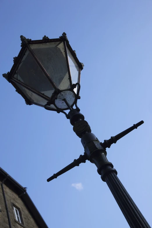 a street light is standing in front of the clock