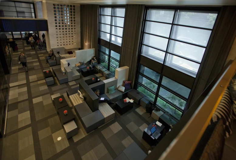 people sit in chairs inside a building as others look on