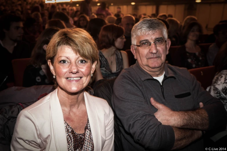 a man and woman standing in front of a crowd